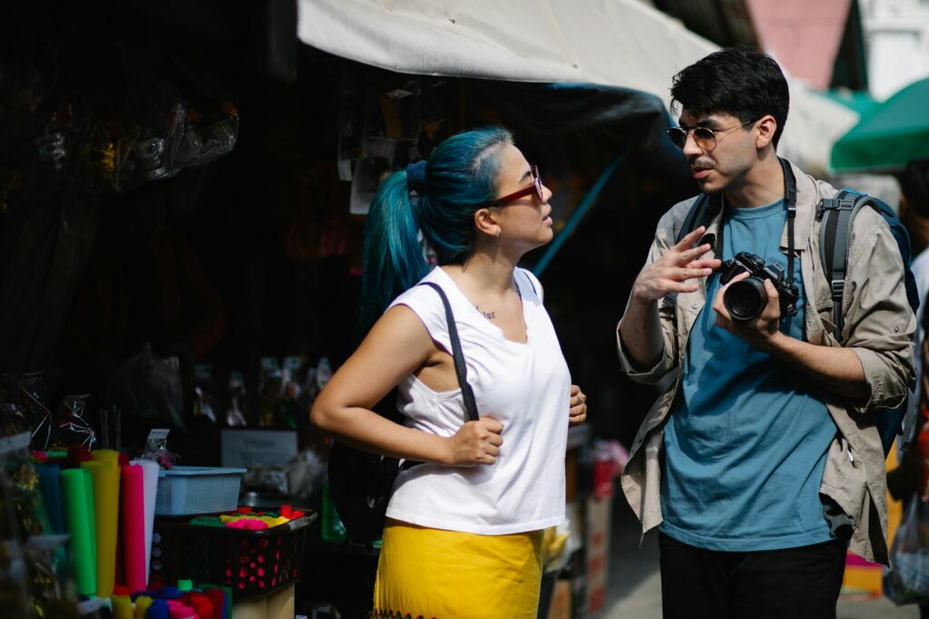 pexels-photo-7968658-7968658 Travelers with a camera chatting in a bustling market